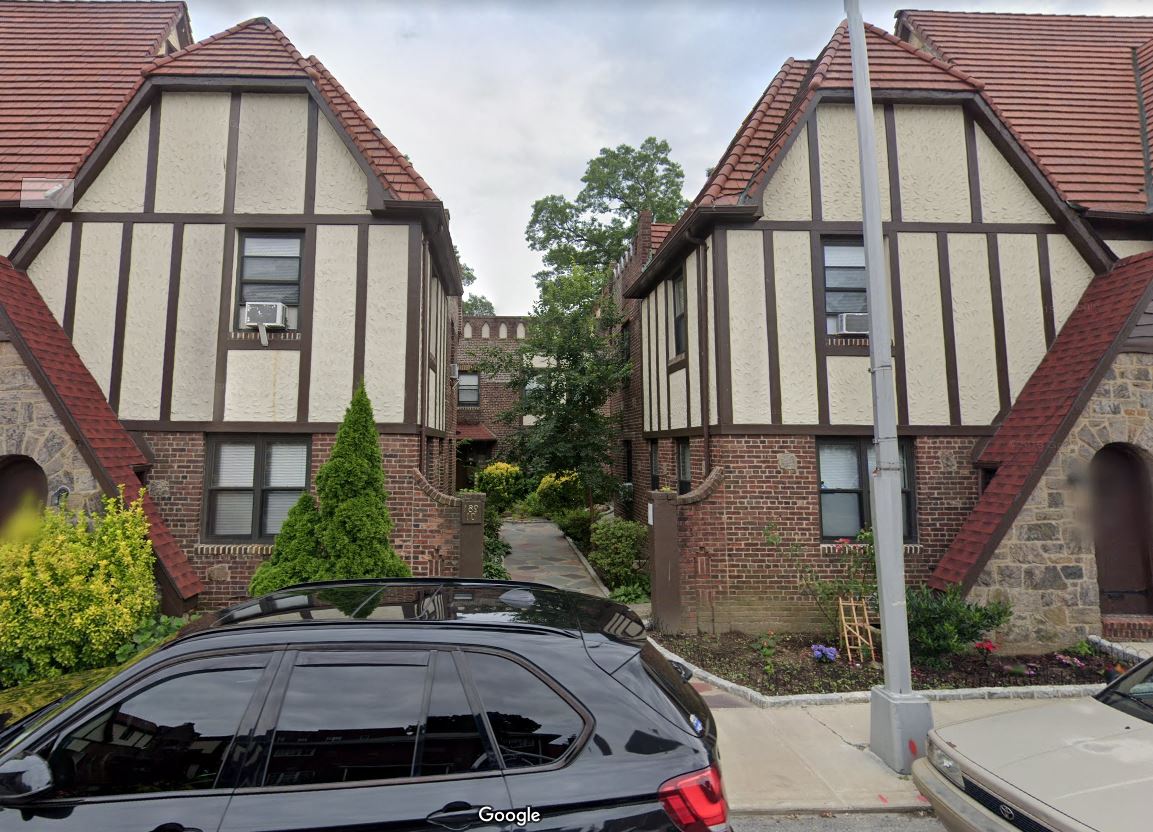 a car parked in a driveway in front of two houses